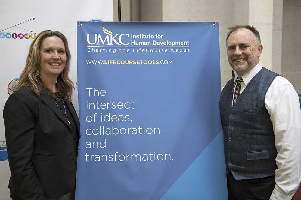 Sheli Reynolds and George Gotto pose with a Charting the LifeCourse Nexus Banner